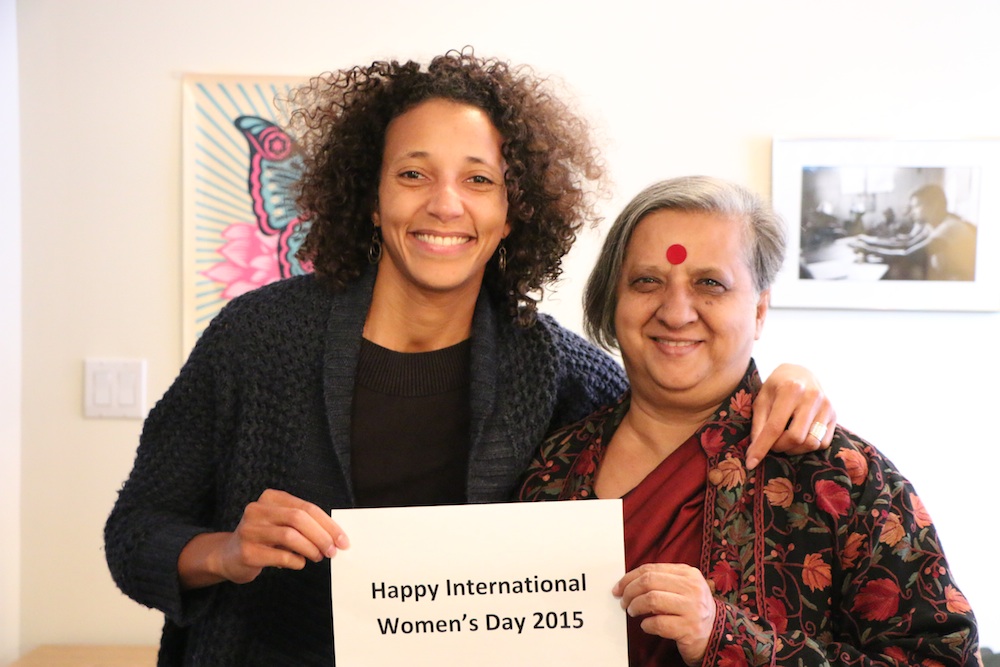 Patricia and Khushi holding a Happy International Women's Day sign