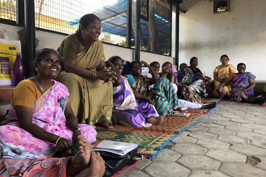 Women representatives of Tamil Nadu Women's Collective sit in a circle, sharing and laughing.
