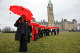 Medicare advocates on Parliament Hill in Ottawa with red umbrellas