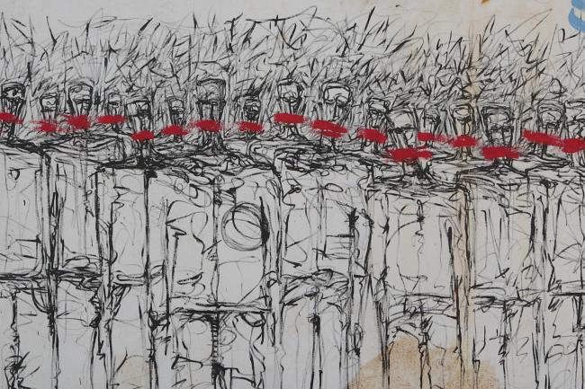 Photograph of graffiti on a white wall. Fine black lines trace stylized outlines of people in a crowd. There are red smears of paint where the people's mouths would be.